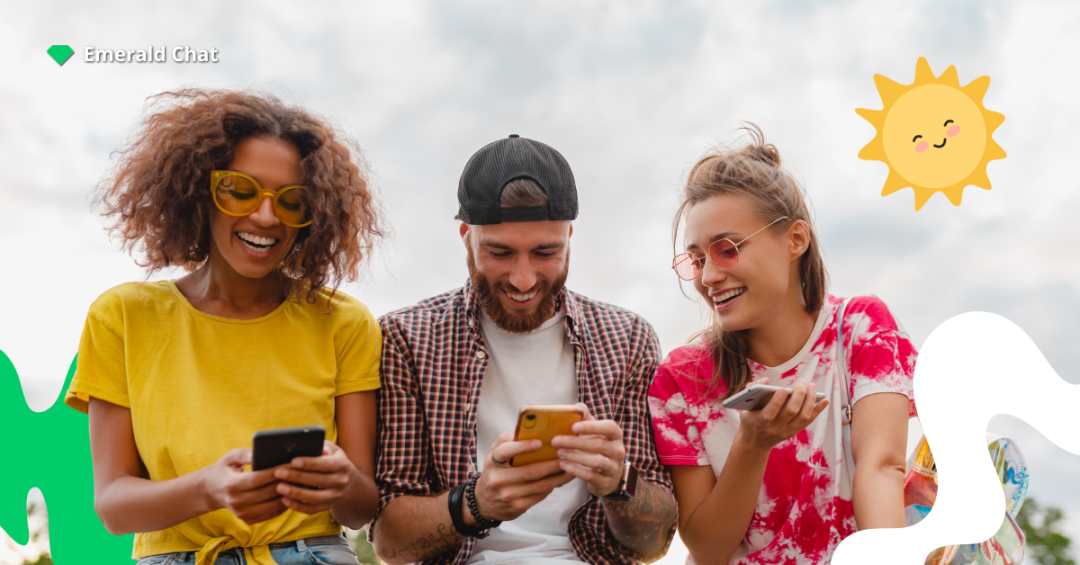 Three friends smiling while using their phones outdoors under a bright sky with playful sun and abstract shapes, representing fun and positive online connections on Emerald Chat.